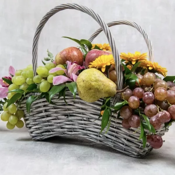 Плетёная корзина с виноградом, грушей, яблоками, жёлтыми герберами и розовой альстромерией