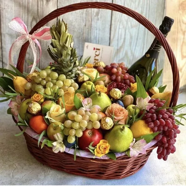 Плетёная корзина с фруктами, персиковыми розами, виноградом и шампанским