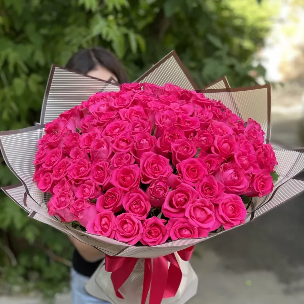 Монобукет из 101 ярко-розовой розы куполом в полосатой бежево-коричневой упаковке с атласной лентой