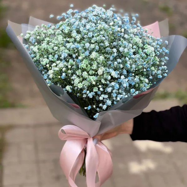 Воздушный букет из голубых и белых гипсофил в серо-розовой упаковке с атласной лентой