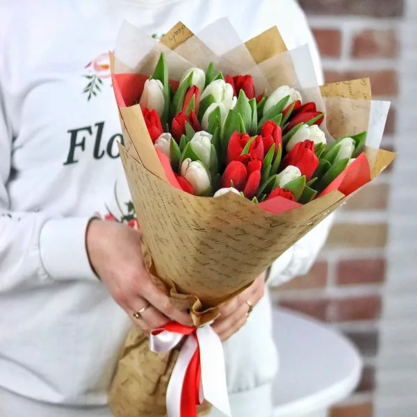 Букет из 25 красных и белых тюльпанов в крафтовой упаковке с белой калькой и атласной лентой