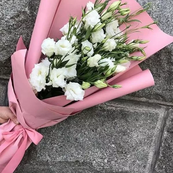 Монобукет из 7 белых эустом с зелёными бутонами в розовой матовой упаковке с атласной лентой