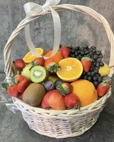 Плетёная белая корзина с апельсинами, клубникой, киви, виноградом и яблоками, атласный бант