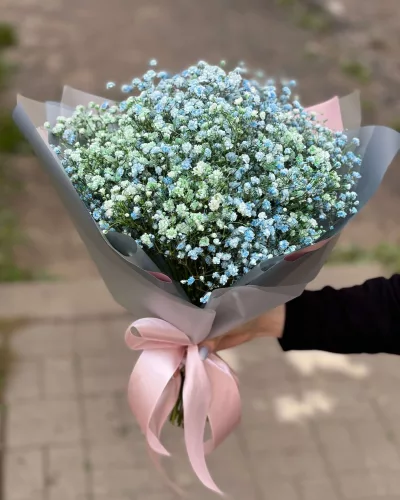 Воздушный букет из голубых и белых гипсофил в серо-розовой упаковке с атласной лентой