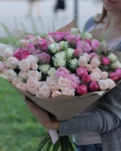 Пышный букет из кремовых, розовых и малиновых кустовых роз с тласпи в крафтовой упаковке