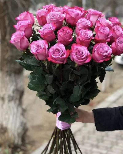 Монобукет из 25 ярко-розовых роз на длинных стеблях, перевязан розовой атласной лентой
