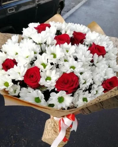 Сборный букет из красных роз и белых кустовых хризантем в крафтовой упаковке с красно-белой лентой