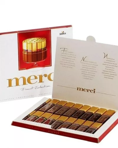 Открытая коробка конфет Merci Finest Selection с рядами шоколадных конфет в золотой обёртке