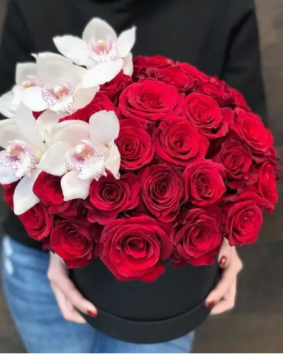 Шляпная коробка с куполом из красных роз и белых орхидей цимбидиум в чёрной коробке