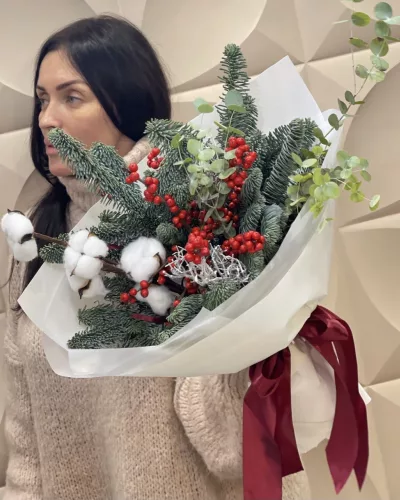 Новогодний букет из ели нобилис, хлопка и красных ягод в белой упаковке с бордовой лентой