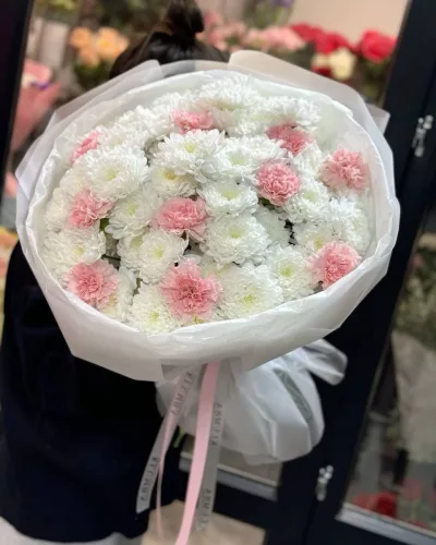 Пышный букет из белых кустовых хризантем с розовыми диантусами в белой упаковке
