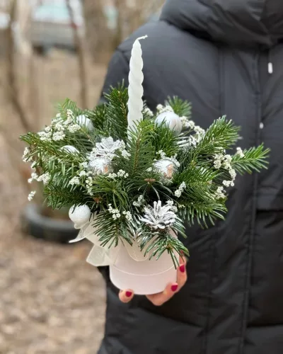 Новогодняя композиция с хвоей, серебристыми шарами и белой витой свечой в белом кашпо