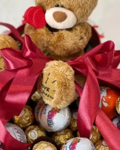 Мягкие медведи с красной атласной лентой, конфеты Kinder и Ferrero Rocher в композиции