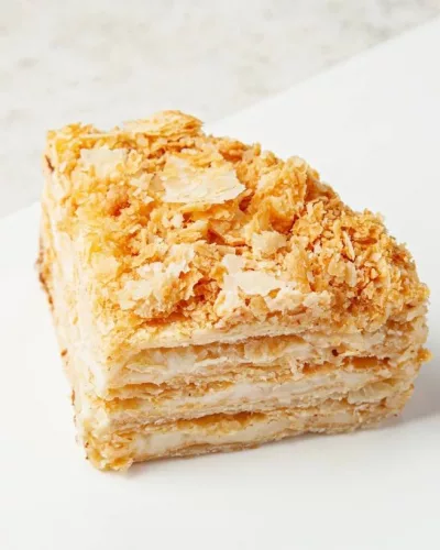 Кусок торта «Наполеон» с хрустящей корочкой, слоистыми коржами и кремовой прослойкой